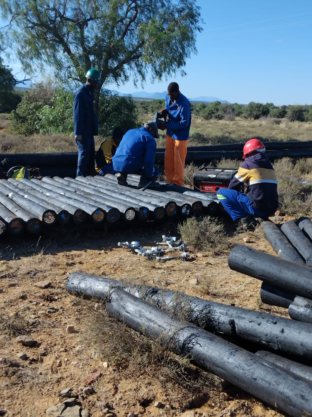 Field team preparing wooden poles and line hardware
